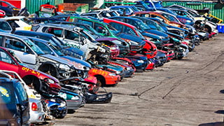 View of wrecking yard showing a mix of dismantled cars.