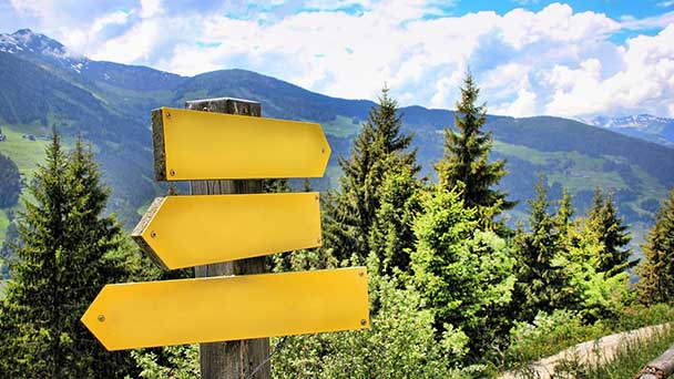 Signpost with 3 directions to different locations.
