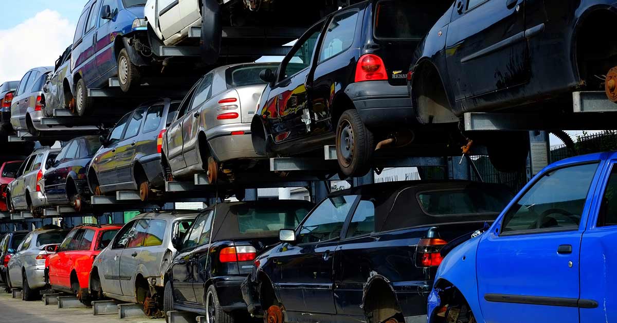 Wrecking yard with stacks of junk cars.