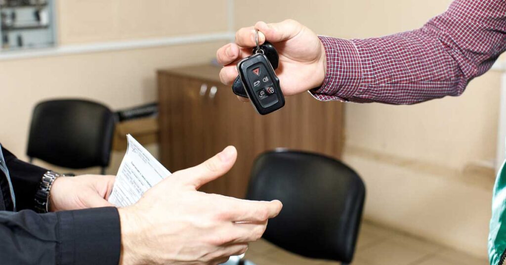 Vehicle owner giving away car keys to the buyer.