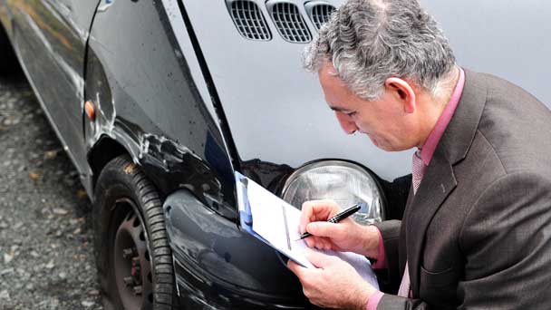 Insurance Expert Checking The Wrecked Car