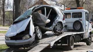 A towing truck removing a wrcked car.