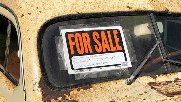 Old rusted car with For Sale sign on windscreen